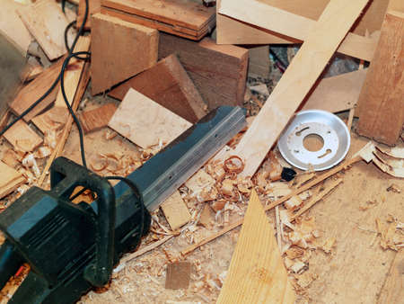 electric saw on the floor of a messy workplace of a carpenter, indoor closeupの写真素材