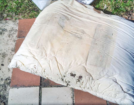 close-up shot of an old moldy pillow, discarded outdoorの写真素材