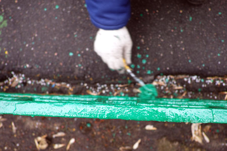 overhead blurred motion shot of a hand with brush painting metal fenceの写真素材