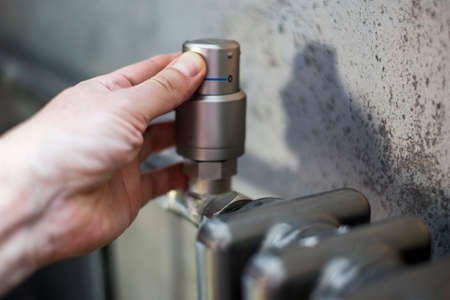 shallow DOF shot of a hand turning room temperature downの写真素材