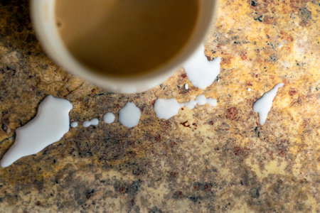overhead closeup shot of a messy table with a cup and spilled milk aroundの写真素材