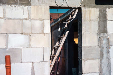 unfinished block building and a ladder in a doorway, outdoor shotの写真素材
