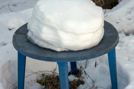 abandoned garden plastic table with a snowdrift on top, winter scene