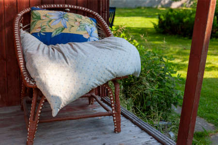 a pillow on a seat of cozy armchair placed on veranda, outdoor sunny day shotの写真素材