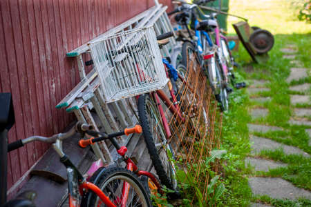 collection of old bicycles and household stuff in a messy backyardの写真素材