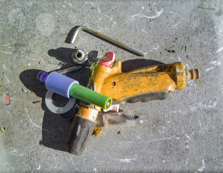 old garden water sprinklers, parts and tools abandoned on the groundの写真素材