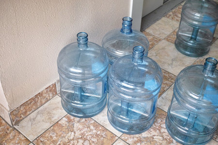 a group of empty plastic bottles for water waiting to be replacedの写真素材
