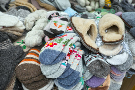 sale of handmade multi-color warm wool socks and slippers displayed outdoorの写真素材