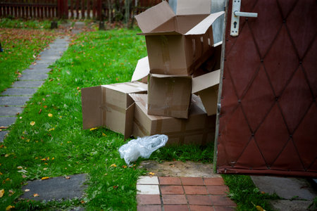 empty cardboard boxes abandoned outside a house, daytime shot