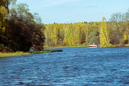 a river and small fishing boat in the backgrounds, autumn landscapeの写真素材