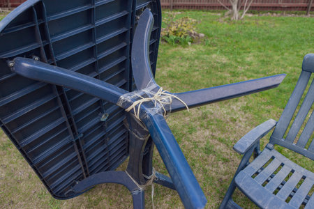 repair of a leg of the plastic garden table with tape and ropeの写真素材