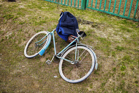 an old bicycle and a jacket abandoned on the ground, outdoor shotの写真素材