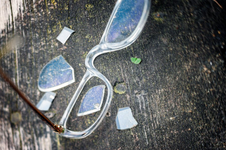 shallow dof shot of a broken spectacles on the wooden background, no people