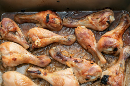 just grilled chicken legs in oil and spices, indoor close upの写真素材