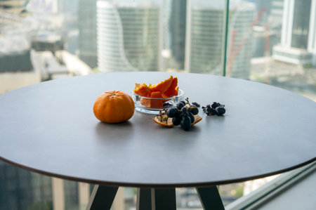 peeling oranges and eating grapes on a balcony table, a morning light shotの写真素材