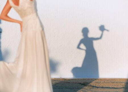 A girl with a bouquet with her shadow.の写真素材