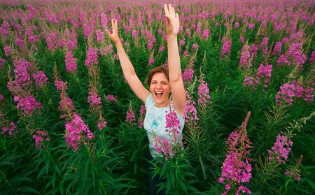Outdoor portrait of a middle aged woman. attractive girl in a field with flowers.の写真素材