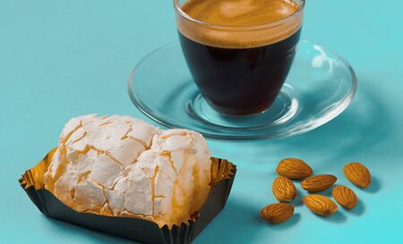 A glass Cup of black coffee with merinque cake and almondの写真素材
