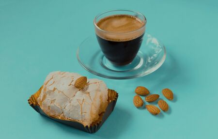 A glass Cup of black coffee with merinque cake and almond. Beautiful breakfast.の写真素材