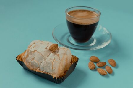 A glass Cup of black coffee with merinque cake and almond. Beautiful breakfast.の写真素材