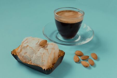 A glass Cup of black coffee with merinque cake and almond. Beautiful breakfast.の写真素材