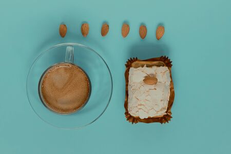 A glass Cup of black coffee with merinque cake and almond. Top view.の写真素材