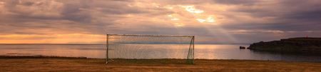 a goal with sunlight shining through clouds at dawn as a background. Concepts of making lots of effort and the hope will become true, mood changes to positive, energy, warmth, vitality, belief in own self.の写真素材