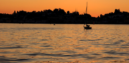 Sailing yacht silhouette at sunset on the lakeの写真素材