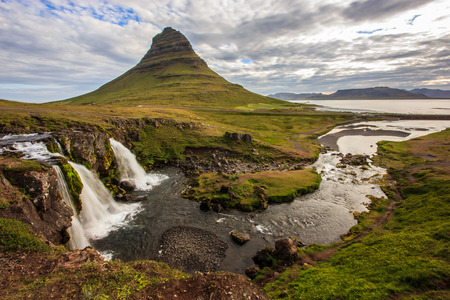 Summer cloudy day with Kirkjufell volcano on the coast of Snaefellsnes peninsula. Idyllic scene of Kirkjufellsfoss waterfall, Iceland,の写真素材
