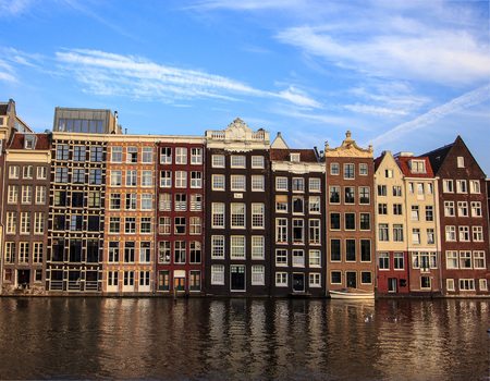 Beautiful traditional old buildings at day with bright blue sky in Amsterdam, the Netherlandsの写真素材
