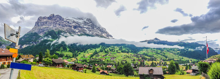 Spectacular Panoramic view with blank signpost on the left of Grindelwald Landscape and Clipping Cloudscape on overcast day, Berne Canton, Switzerland, Europe. Starting village for First and Jungfrau.の写真素材