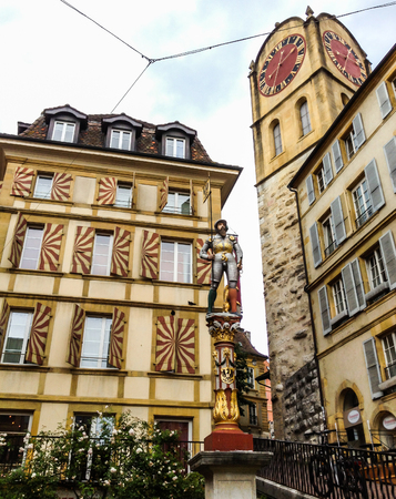The Banneret polychrome statue surmounted on the beautiful fountain dated back to 1581 near the Croix du Marche which is surrounded by Renaissance building's facade, Neuchatel, Switzerlandのeditorial素材