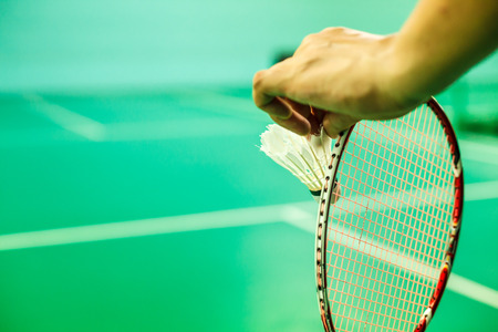 Closeup Badminton player hand holding the shuttle cock together with the racket, ready to serve...