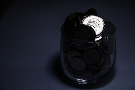 dark money coins in glass black backgroundの写真素材