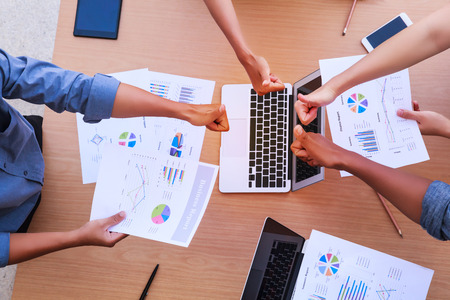 Top view of businessmen and businesswoman thumbs up over table in a meeting with copy space at...