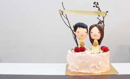 sugar icing happy smiling couple lovers figure on delicious cake with paper banner on sticks. Birthday Celebration, Anniversary, Happiness conceptの写真素材