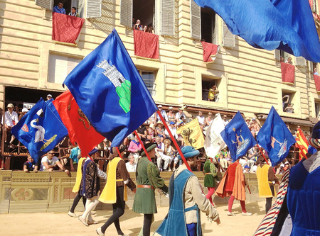 Siena, Italy - July 02, 2012: tourists watching the colorful and fancy traditional costume parades at the horse race, Palio di Siena, held in medieval square Piazza del Campo twice a year in Siena.のeditorial素材