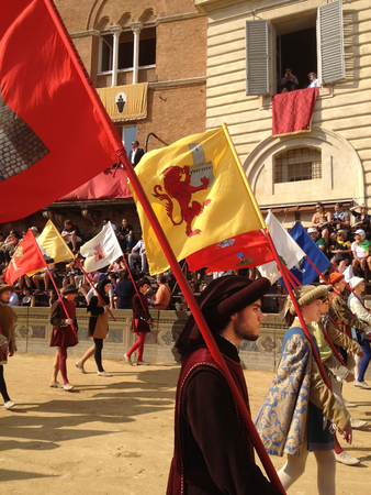 Siena, Italy - July 02, 2012: tourists watching the colorful and fancy traditional costume parades at the horse race, Palio di Siena, held in medieval square Piazza del Campo twice a year in Siena.のeditorial素材