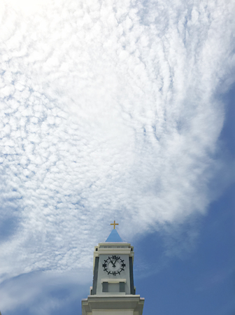 Cross on Clock tower with Cirrocumulus cloud and sky backgroundの写真素材