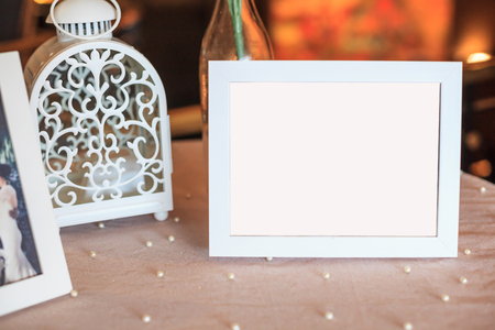 Blank wooden picture frame decoration on table decorated by white tablecloth. Wedding reception ceremony, anniversary celebration, interior concept.の写真素材