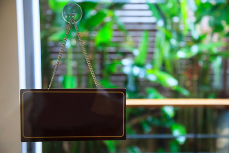 Blank empty wooden door hanger (hanging  banner or signboard) with suction cup (vacuum wall hook, sucker) that grips smooth glass surface. Use for Info, message, communication, advertisement concept.の写真素材