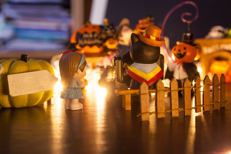 girls waiting for photo shoot at pumpkin entrance with blank signboard welcome to Halloween festival party house. Festive Celebration, Holidays, Fun, Halloween toy and doll decoration theme concept.の写真素材