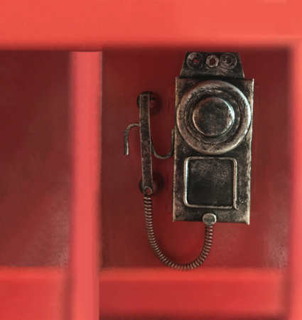 traditional classic red phone box, in which conventional wall dial rotary phone is attached, ready to dial call. Retro furniture, Interior vintage design, Obsolete telecommunication technology conceptの写真素材