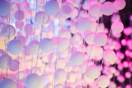 decorating light white pink color hanging polystyrene plastic ball sphere curtain on outdoor stage setting. Abstract, Background, Backdrop, Wallpaper, Decoration and Stage Light Illumination concept.の写真素材