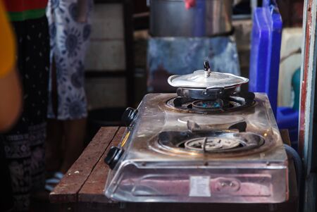 fresh boiling food in stainless steel pan on hot gas fueled stove, prepared for frying breakfast meal food in indoor kitchen background. Kitchen utensils, Cooking tools and equipment design concept.の写真素材