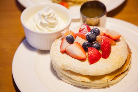 Fresh red strawberries and blackberries fruit toppings on pancake seasoned with whipped cream. Healthy sweets, desserts, snack, bakery, starters, treats, cuisine, confectionery and gourmet conceptの写真素材