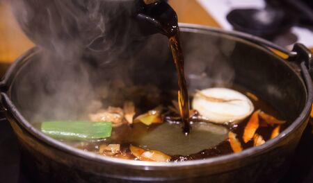 Selective Focused Pot Pouring Soup on Japanese nabemono hotpot dish of thinly sliced meat boiled in water served with dipping sauces, known as Shabu-Shabu. Traditional Japan Soup Food Menu conceptの写真素材