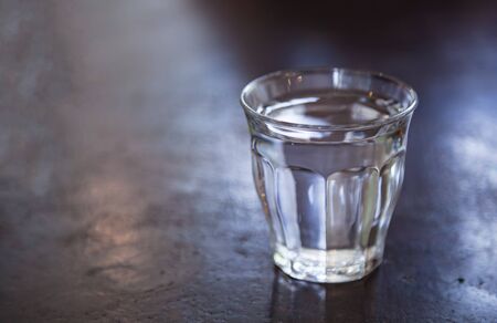 a glass of room temperature drinking water on the stone table background. Refreshment, Drink mild clean water to maintain body temperature for heat stroke prevention, Healthcare concept.の写真素材