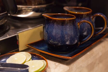 Hand Crafted Vintage Asian Tea Drinking Jugs placed in earthenware tray on table floor, ready to use. Liquid serving containers used in Food and Drink Catering Service Industry, Utensils concept.の写真素材