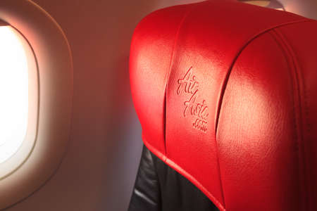 Bangkok, Thailand - June 10, 2019: Air Asia Airline Logo imprinted on the red leather seat headrest...